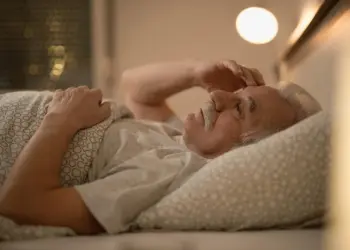 Does lack of sleep cause heart problems – older man lying awake in bed at night