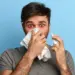 Man experiencing nasal congestion and shortness of breath while using nasal spray