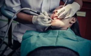 A dentist performing a dental procedure on a patient to treat a tooth infection. This image supports the article “How long until a tooth infection kills you” by showing professional treatment that helps prevent serious complications and life-threatening outcomes.