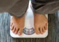 Can sleep apnea cause weight gain shown by person standing on a weighing scale