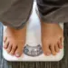 Can sleep apnea cause weight gain shown by person standing on a weighing scale