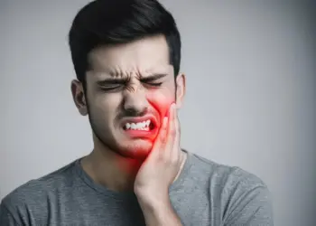 How long until a tooth infection kills you – man holding jaw in severe tooth pain